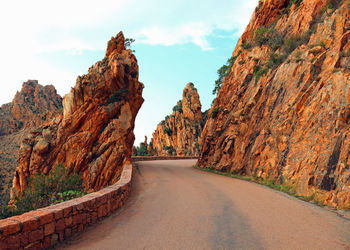 Road amidst rock formation against sky