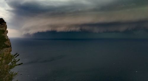 Scenic view of sea against storm clouds