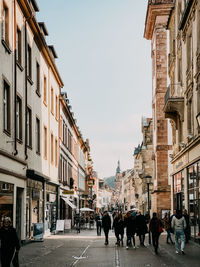 People walking on street amidst buildings in city