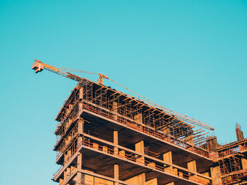 Low angle view of under construction building against clear blue sky