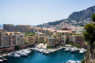 High angle view of townscape by sea against clear sky