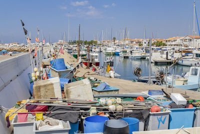 Boats moored at harbor against sky