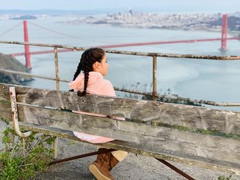 Woman standing by railing against sea