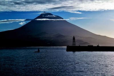 Scenic view of calm sea against mountain range