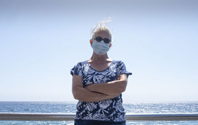 Man wearing sunglasses against sea against clear sky