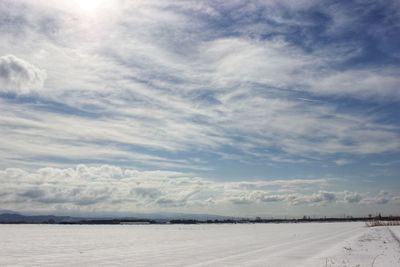 Scenic view of snow covered land against sky