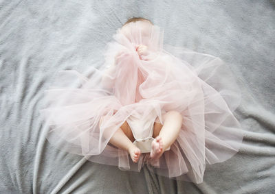 High angle view of baby girl lying on bed at home