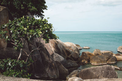 Rocks by sea against sky