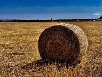 Hay bales on field against sky