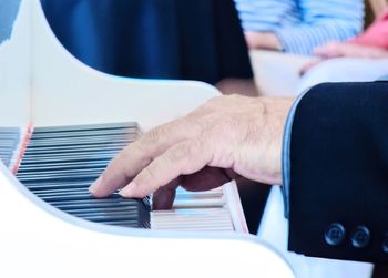 Cropped hand of man playing piano