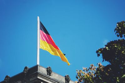 Low angle view of german flag on building against sky