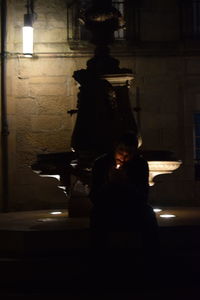 Man and woman in illuminated statue at night