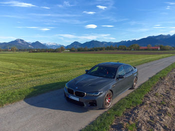 Car parked on field against sky