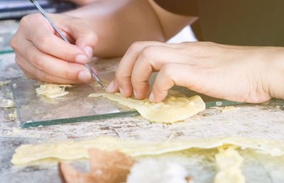 Close-up of person preparing food at table