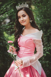 Portrait of smiling woman wearing crown standing outdoors