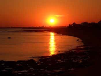 Scenic view of sea against orange sky