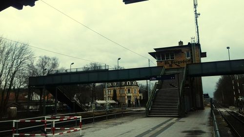 Footbridge over city against sky