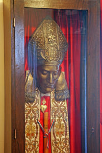 Close-up of buddha statue against door