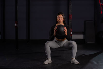 Full length of young woman sitting at home