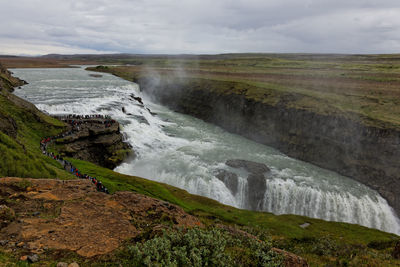 Scenic view of waterfall against sky
