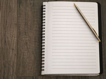 Directly above shot of spiral notebook on wooden table