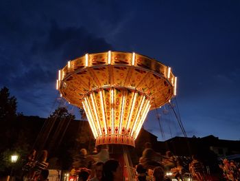 Low angle view of illuminated ferris wheel against sky at night