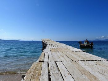 Pier over sea against blue sky