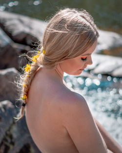 Midsection of shirtless woman in water