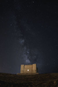 Low angle view of building against sky at night with milkyway