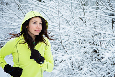 Cold weather running. happy woman running in winter snowy park, forest. running athlete woman