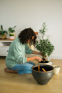 Rear view of woman holding potted plant