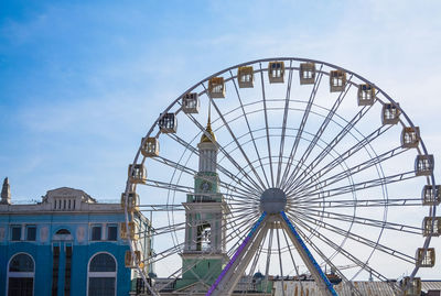 Low angle view of ferris wheel against buildings