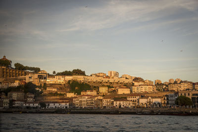 Buildings by sea against sky in town