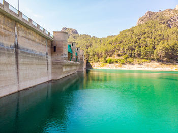 Swimming pool by lake against sky