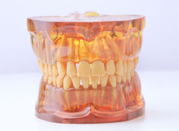 Close-up of artificial glass on table against white background