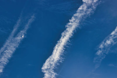 Low angle view of vapor trail against blue sky