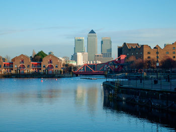 Houses by river against blue sky