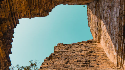 Low angle view of old ruins against clear blue sky