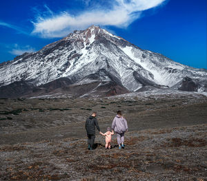 Rear view of man and snowcapped mountain against sky