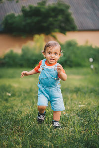 Full length of cute boy running on field