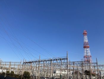 Low angle view of communications tower against blue sky