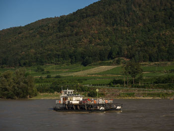 Boat in river against mountains