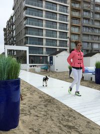 Woman with dog against building