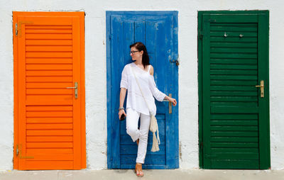 Young woman standing against colorful doors. lifestyle background