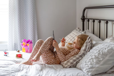 Full length of girl using digital tablet at home