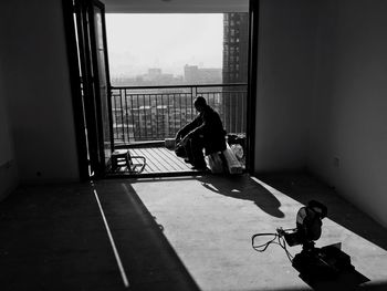 Man sitting in balcony at city