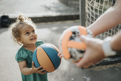 Girl playing ball with parent