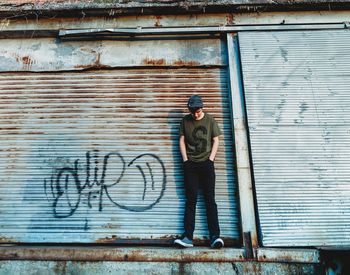 Full length of young man standing against wall