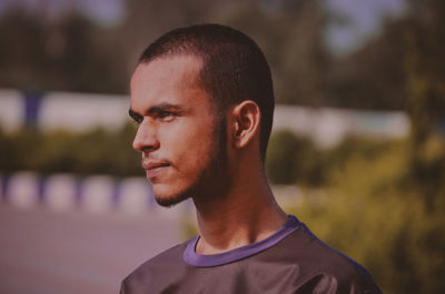 Portrait of young man looking away outdoors