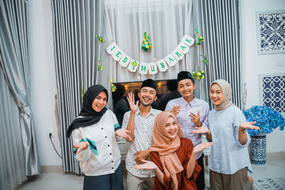 Portrait of smiling friends standing at home